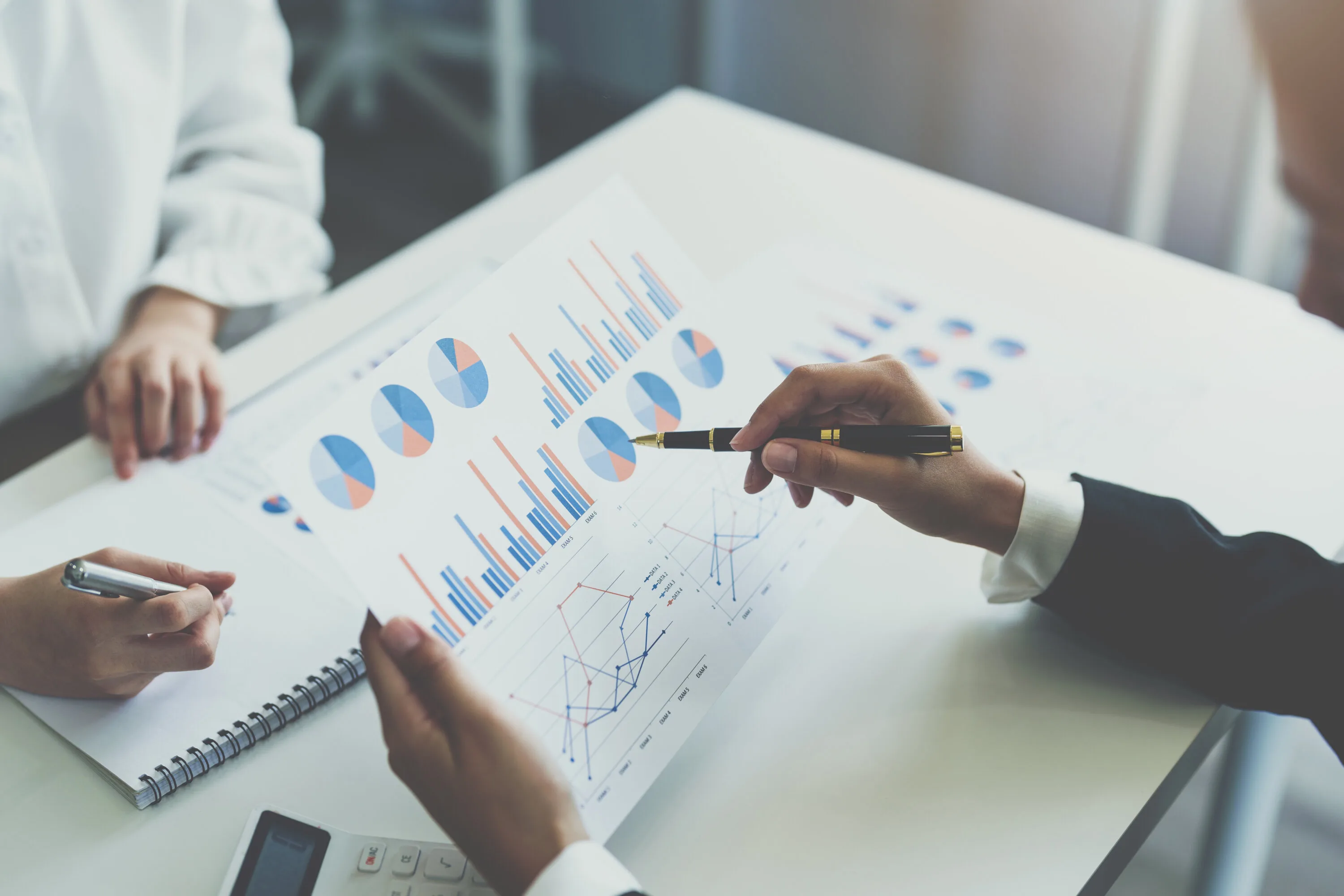 Two business woman investment consultant analyzing company annual financial report balance sheet statement working with documents graphs. market, office,money and tax concept.