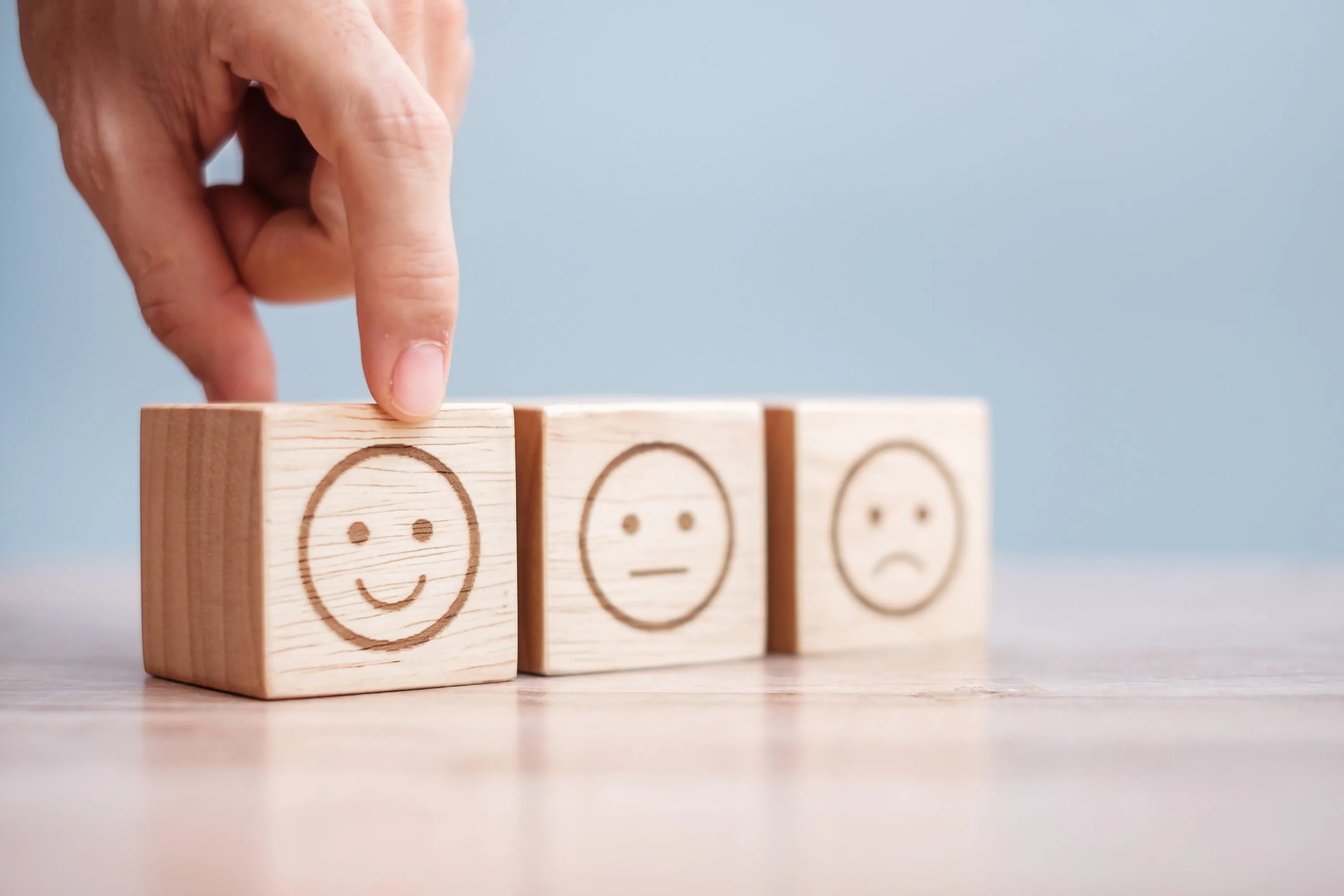 Man hand holding emotion face block. Customer choose Emoticon fo